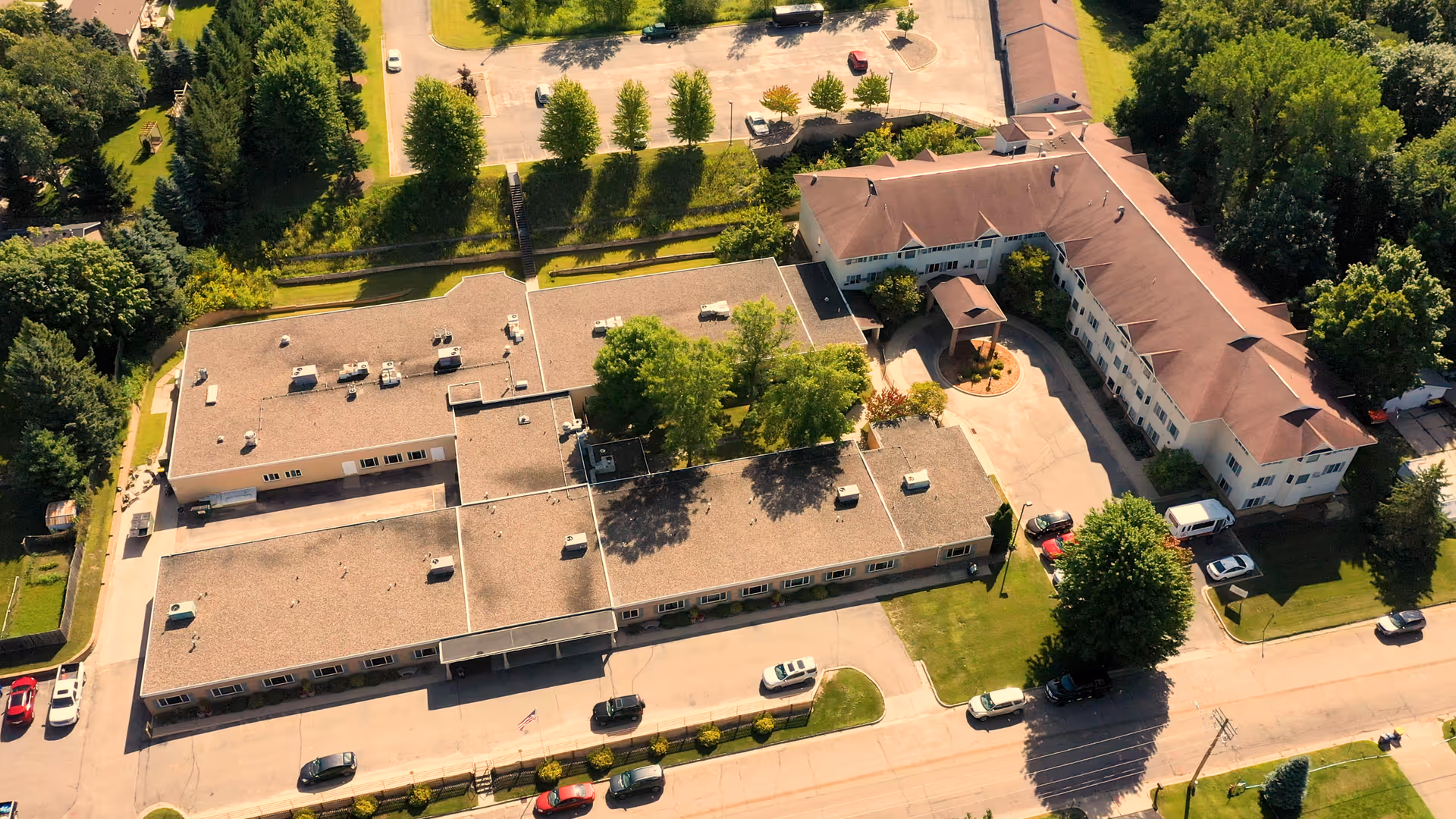 Aerial view of Pleasant View Estates senior living campus with parking and trees.