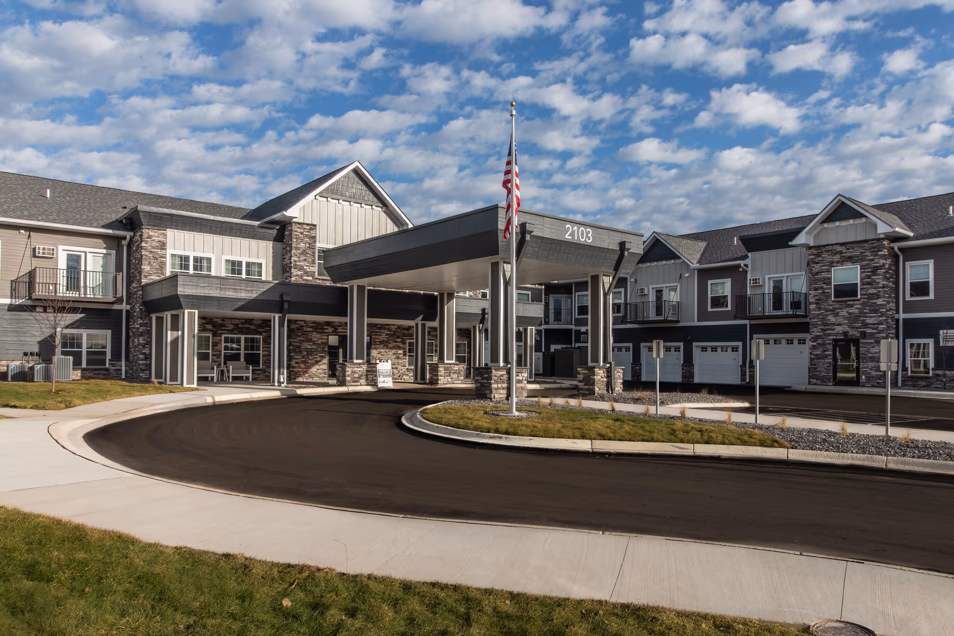 Exterior view of The Crossings of Willmar showing entrance, driveway, and flagpole