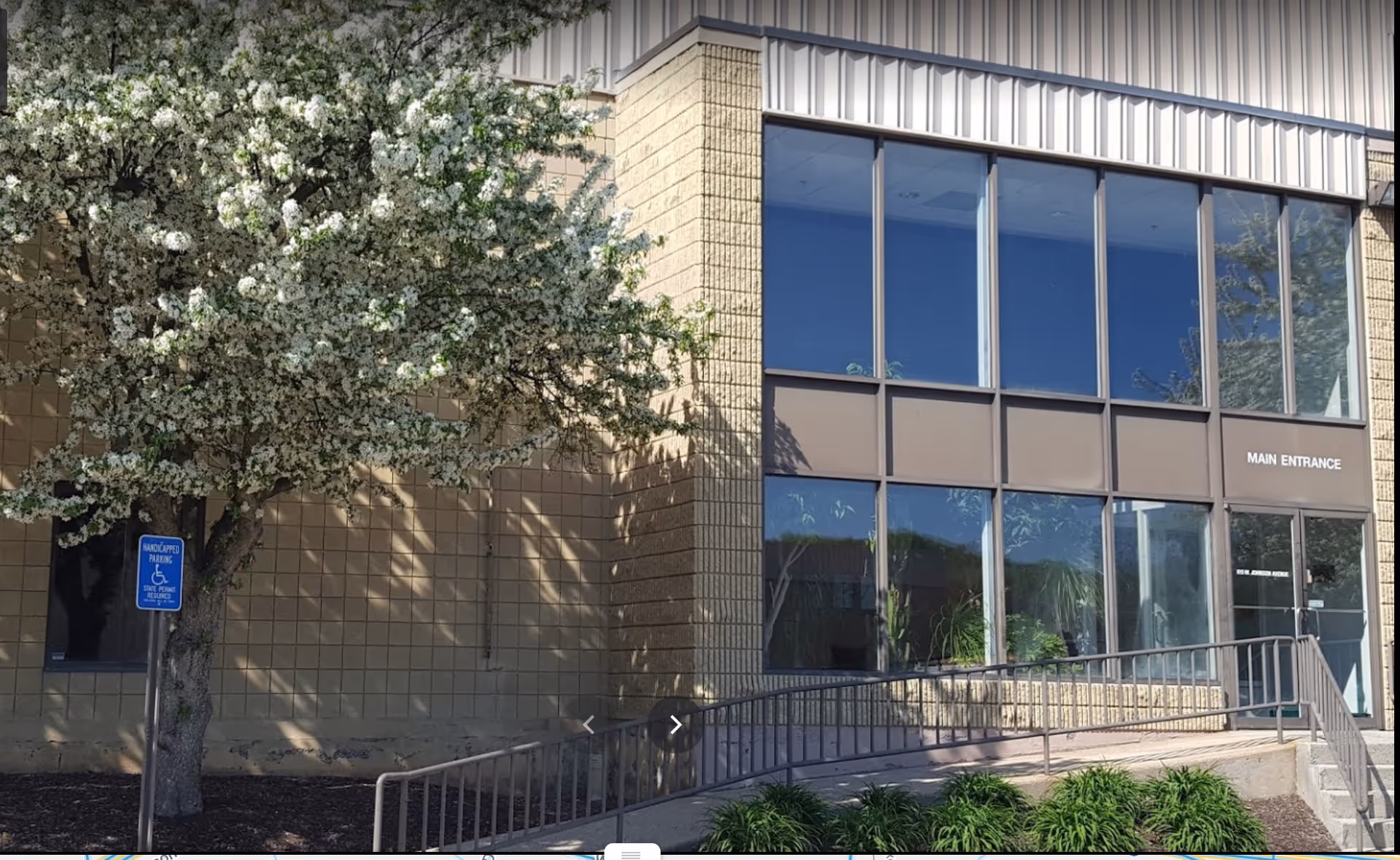 Exterior view of U-turn Health building with large windows, main entrance, ramp, and landscaping.