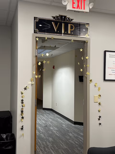 Interior hallway with a VIP doorway decorated with star garland and an EXIT sign.