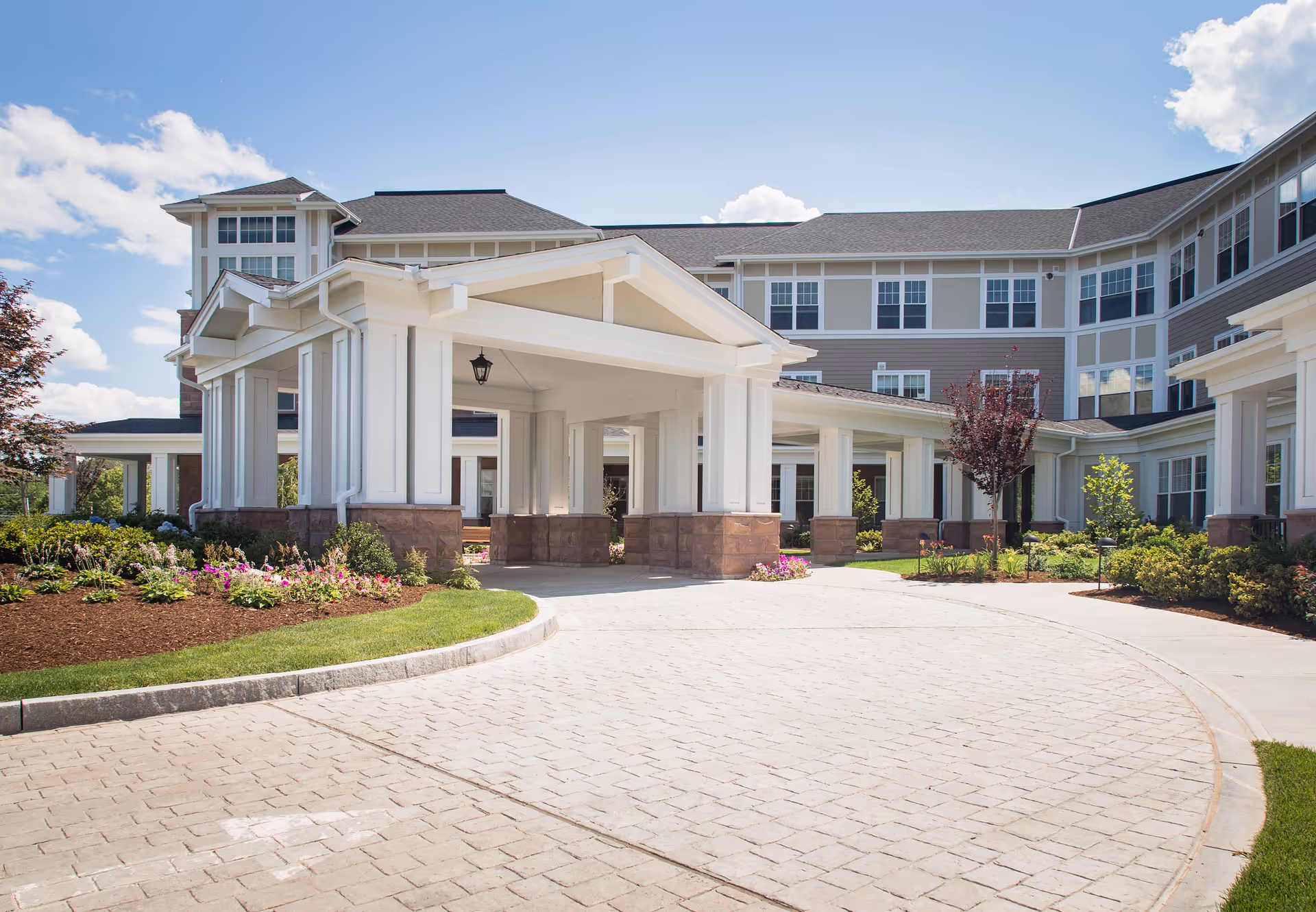 Front entrance of a large senior living facility with a covered porte-cochere.