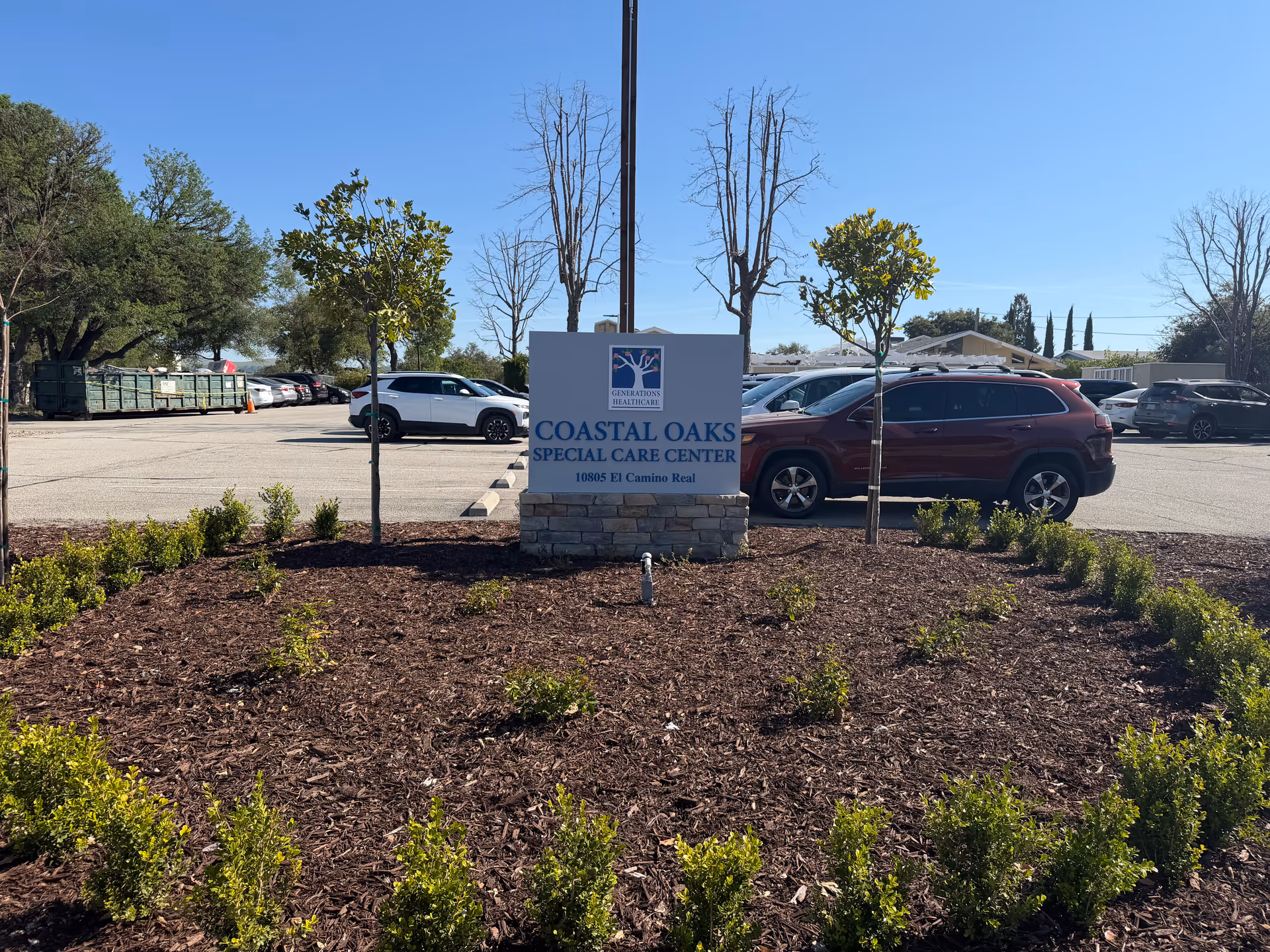 Exterior view of a parking lot with a sign reading Coastal Oaks Special Care Center.