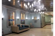A spacious interior lounge with sofa, chairs, wall art, and chandeliers in Daleview Care Center.