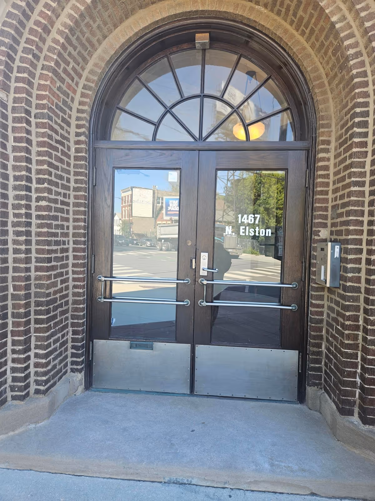 Brick exterior with an arched doorway and glass double doors at the facility entrance.