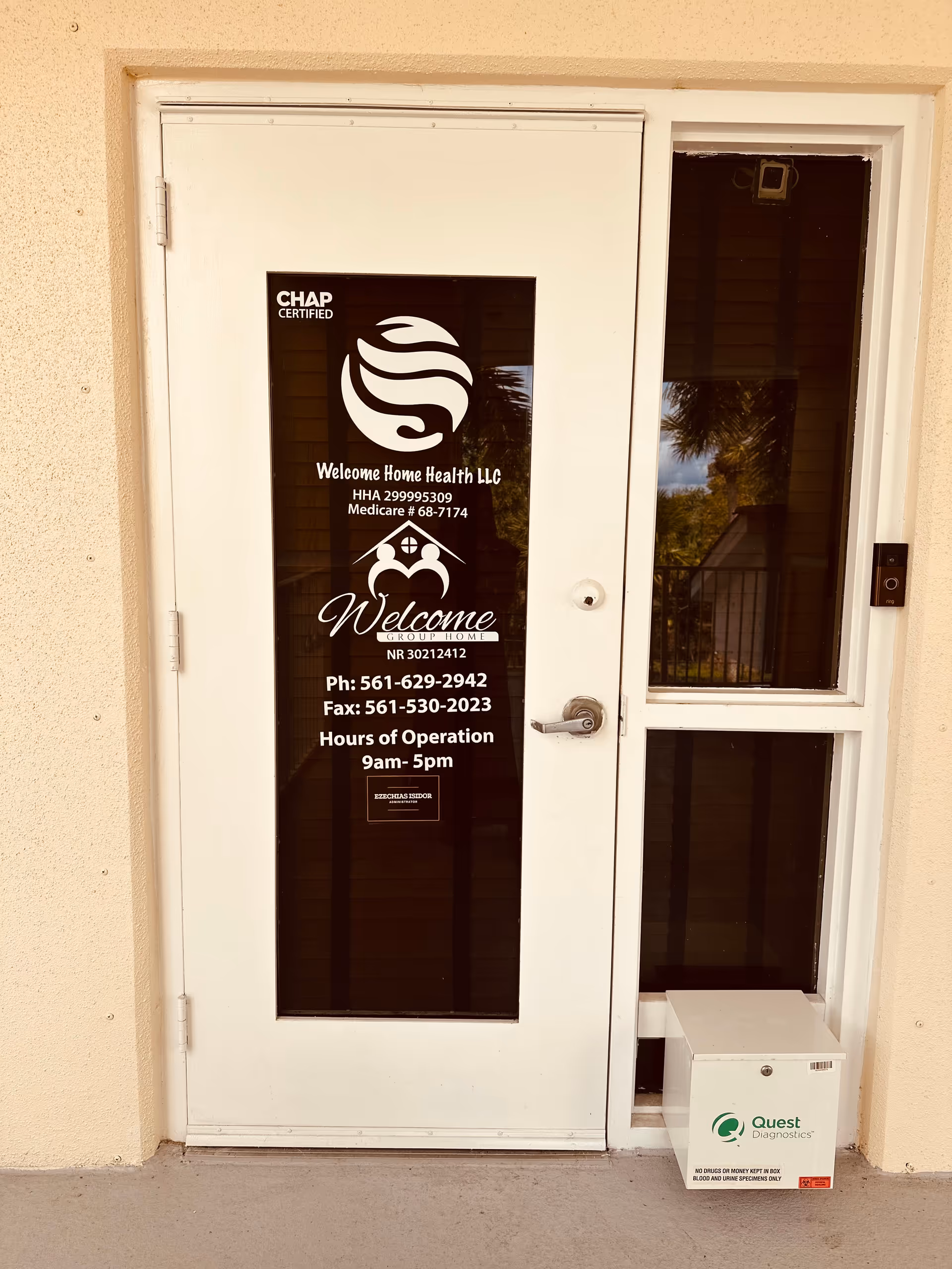 Exterior white entry door with glass panel bearing Welcome Home Health LLC signage and logo.