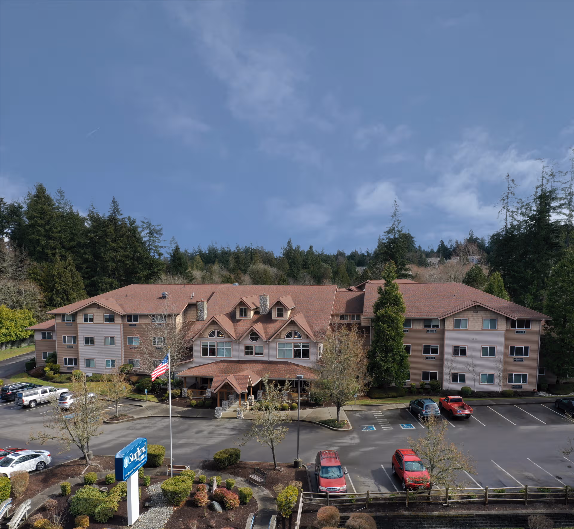 Exterior view of Vineyard Park of Port Orchard, a multi-story senior living building with parking.