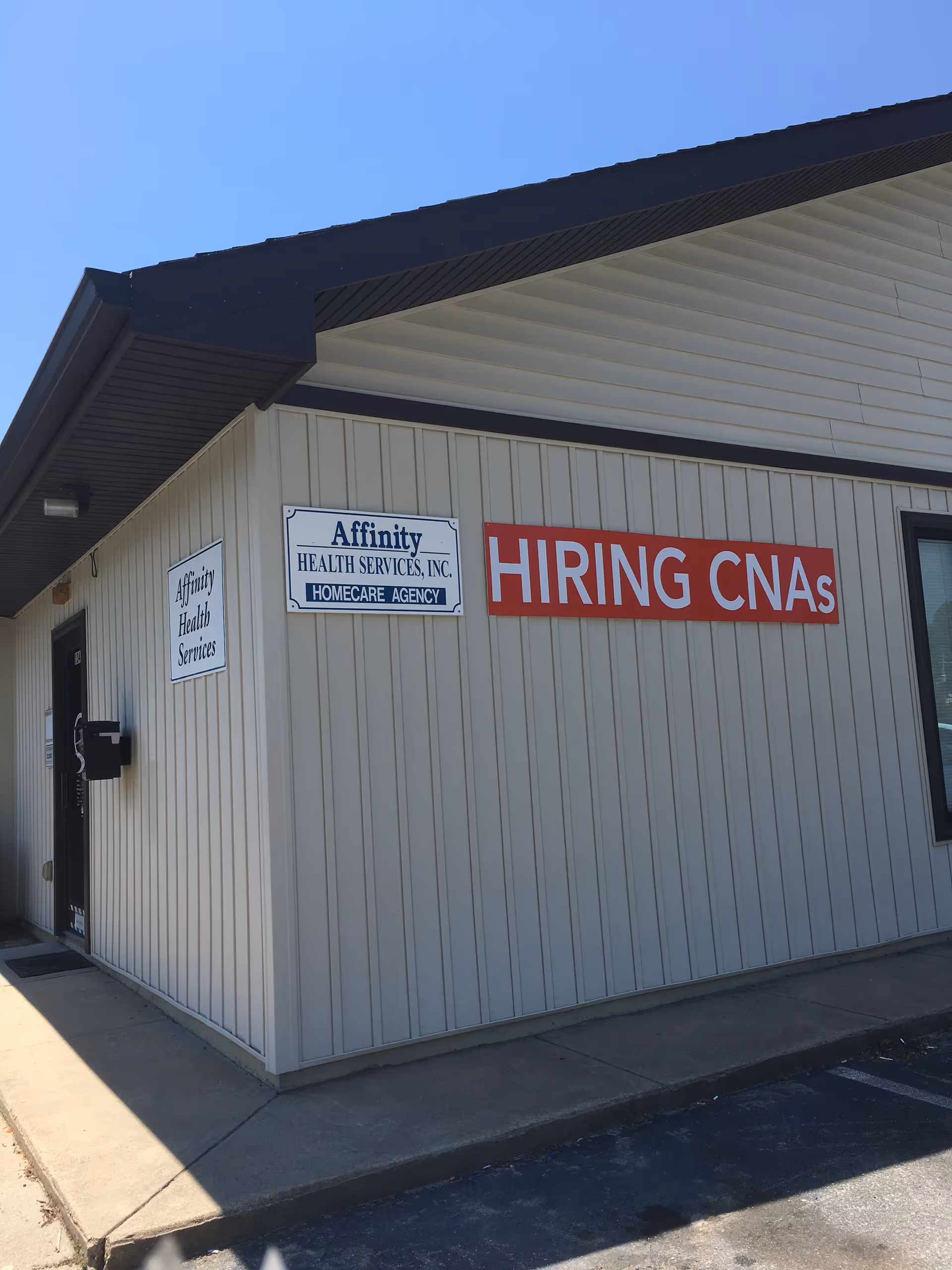 Exterior view of a beige building with Affinity Health Services and HIRING CNAs signs.