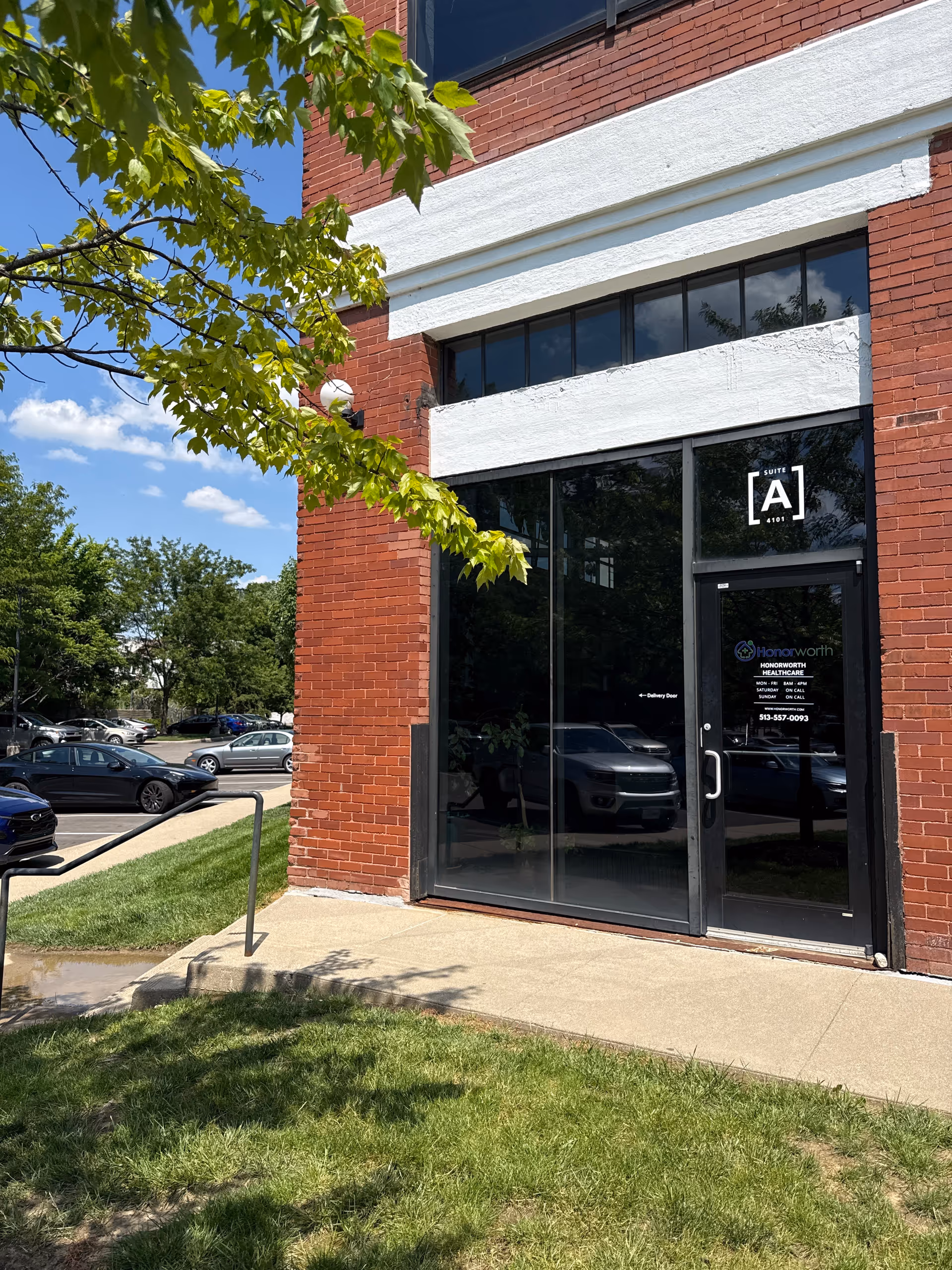 Front of a brick building entrance with glass doors and an Honorworth Homecare sign