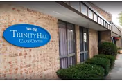 Exterior view of Trinity Hill Care Center sign on brick building facade.