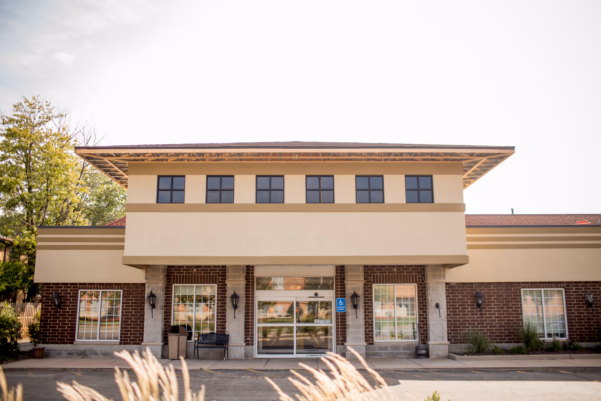 Exterior view of a two-story senior living building with brick and beige accents.