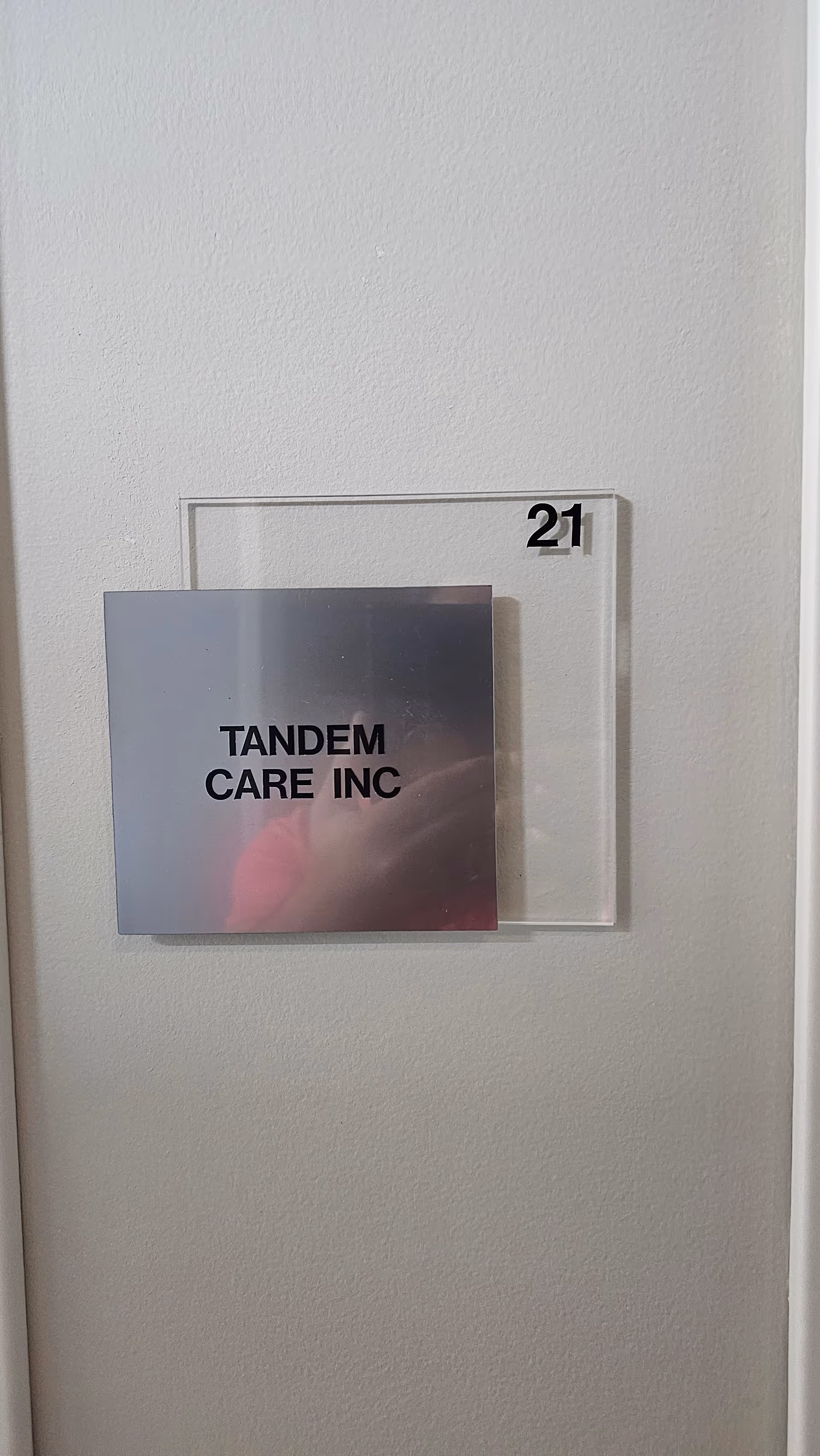 Interior wall plaque showing Tandem Care Inc and room number 21