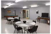 Common area with round tables, chairs, a pool table, and a TV.