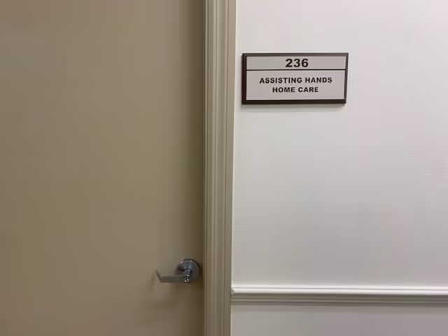 Interior hallway with a door and plaque reading 236 Assisting Hands Home Care.