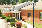 Carriage Inn Of Cadiz exterior with brick facade, entry awning, and landscaped shrubs.