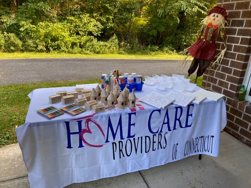 Outdoor table displays crafts and a banner for Home Care Providers of Connecticut.