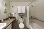 Modern bathroom with sink, toilet, and tiled shower in a senior living facility.
