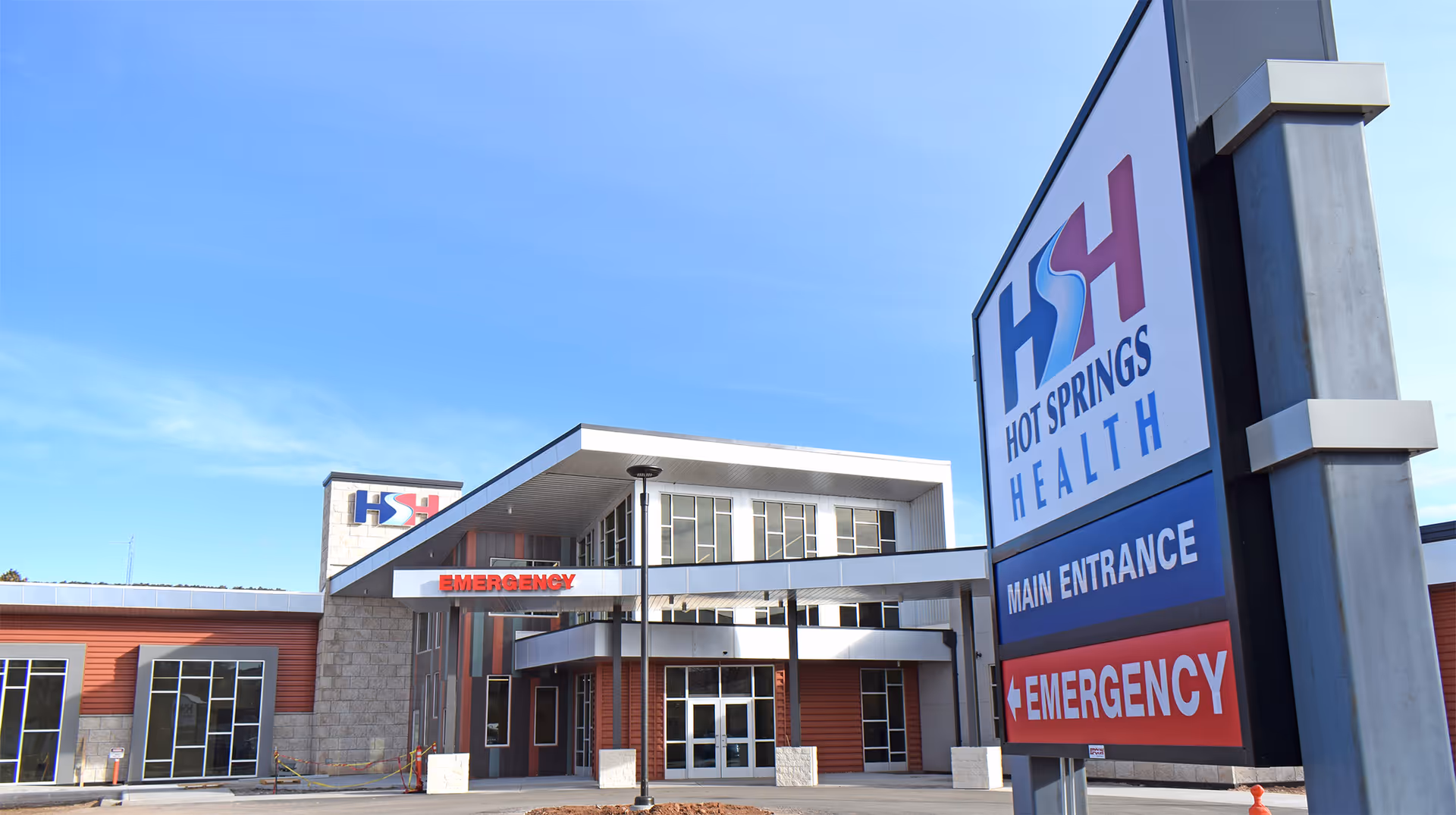 Exterior view of Hot Springs Health facility with main entrance and emergency signage.