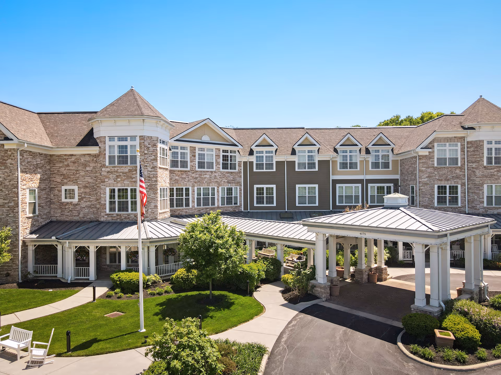 Exterior view of Sunrise of Dublin with entrance canopy, flag, and well-kept landscaping.