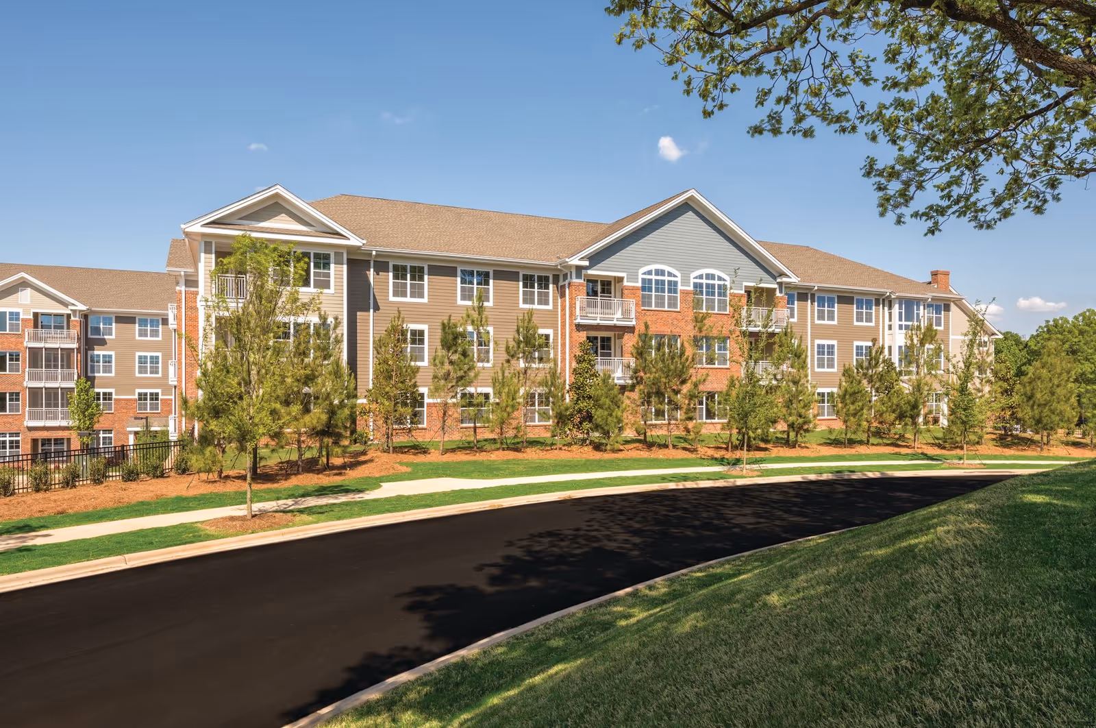 A multi-story Windsor Run senior living building viewed from the street with trees.