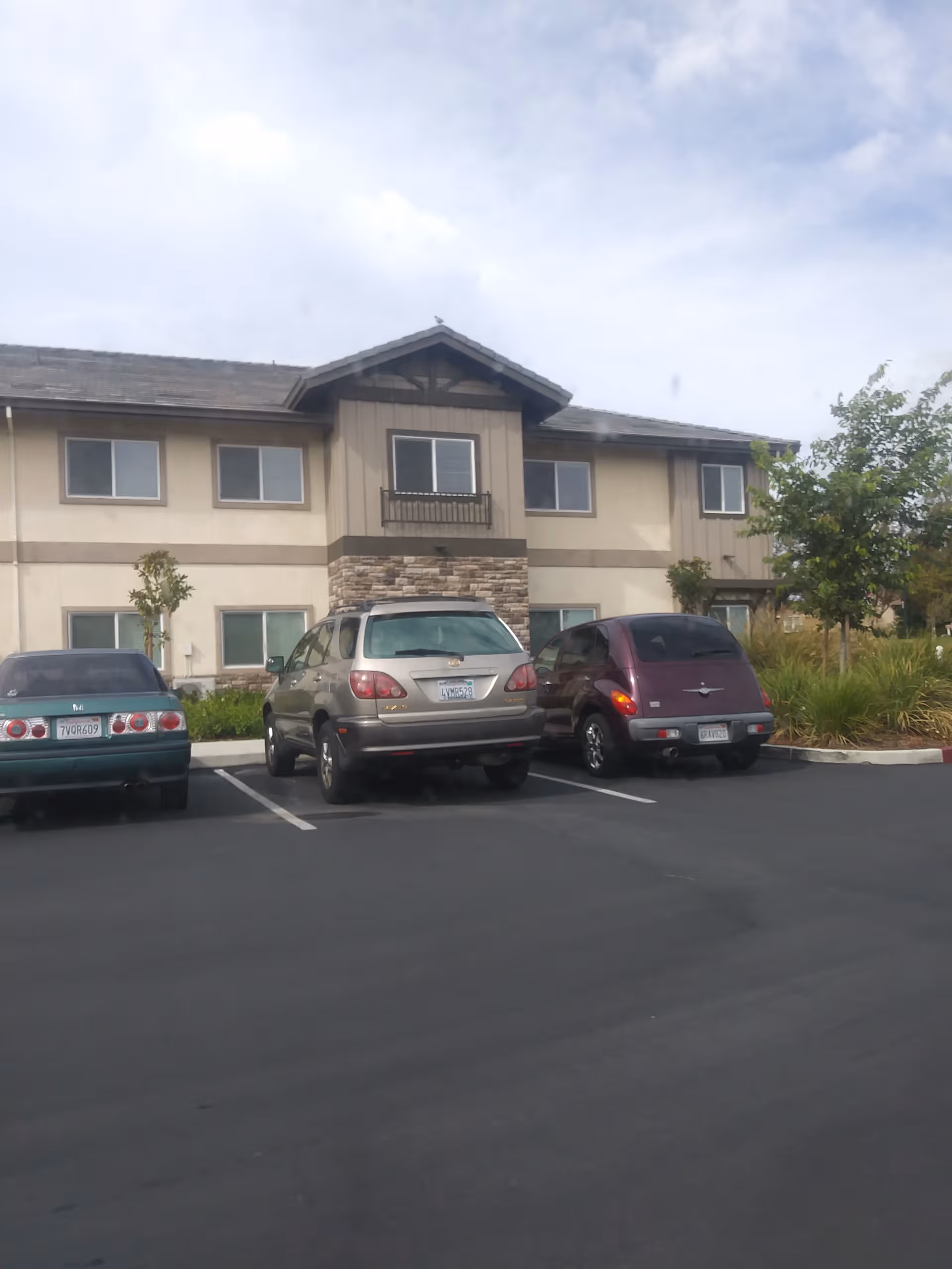 Exterior view of Ivy Park at Rockville with parked cars in front of the building.