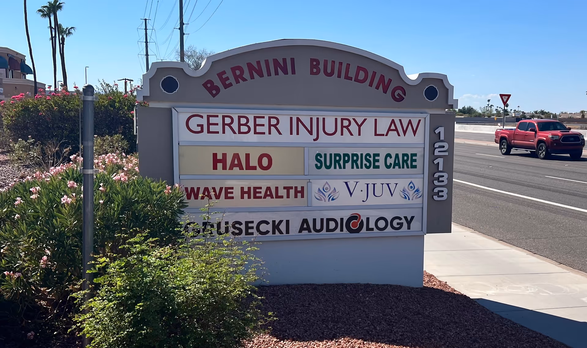 Surprise Care signboard on a building front beside a busy street.