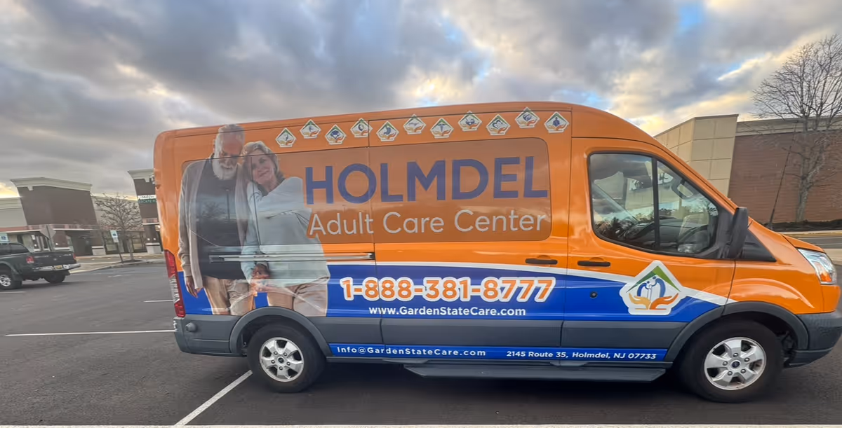 Orange Holmdel Adult Care Center van with logo and phone number parked in a lot