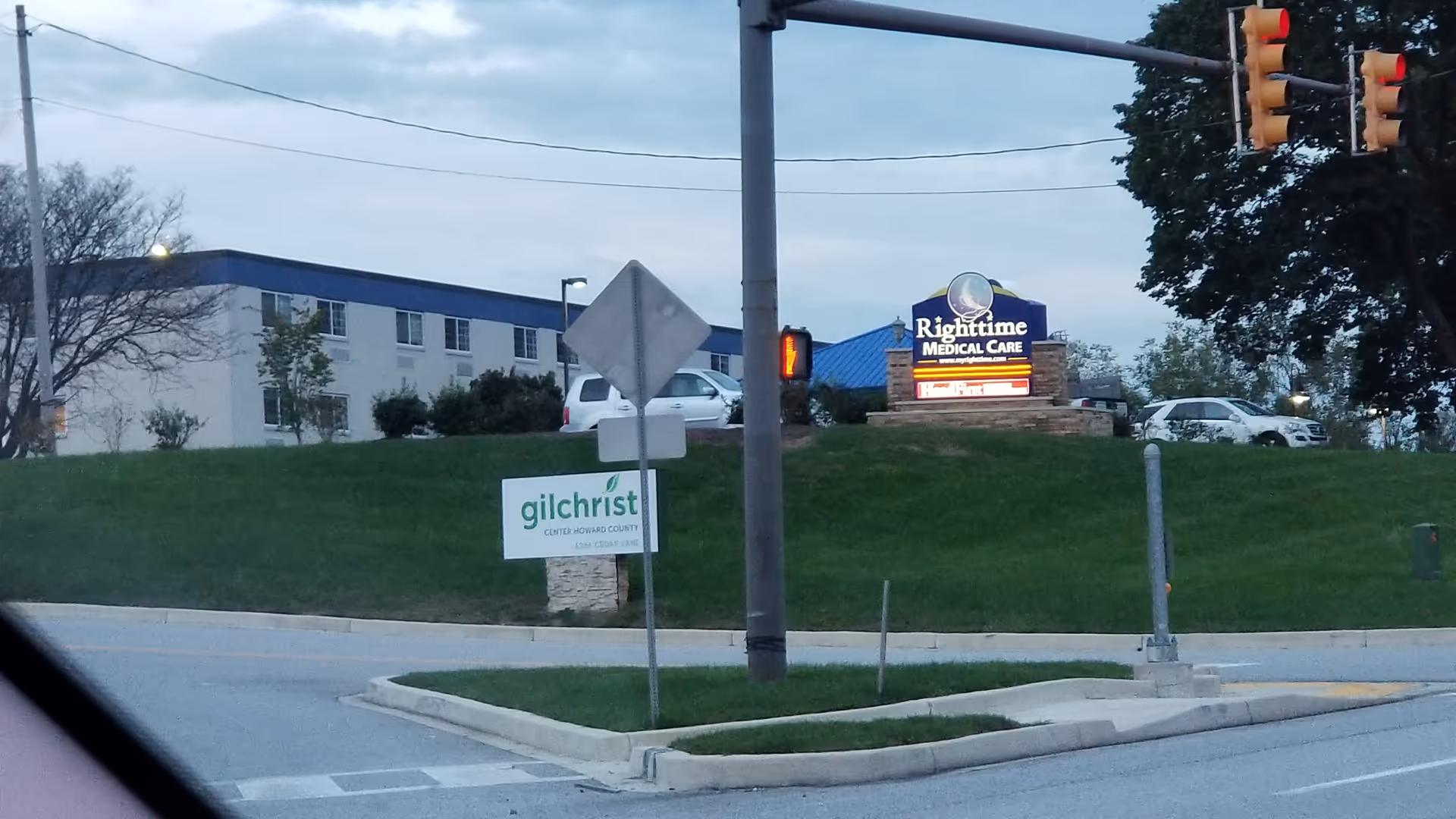 Exterior view of Gilchrist Center Howard County with roadside signs on a grassy hill.