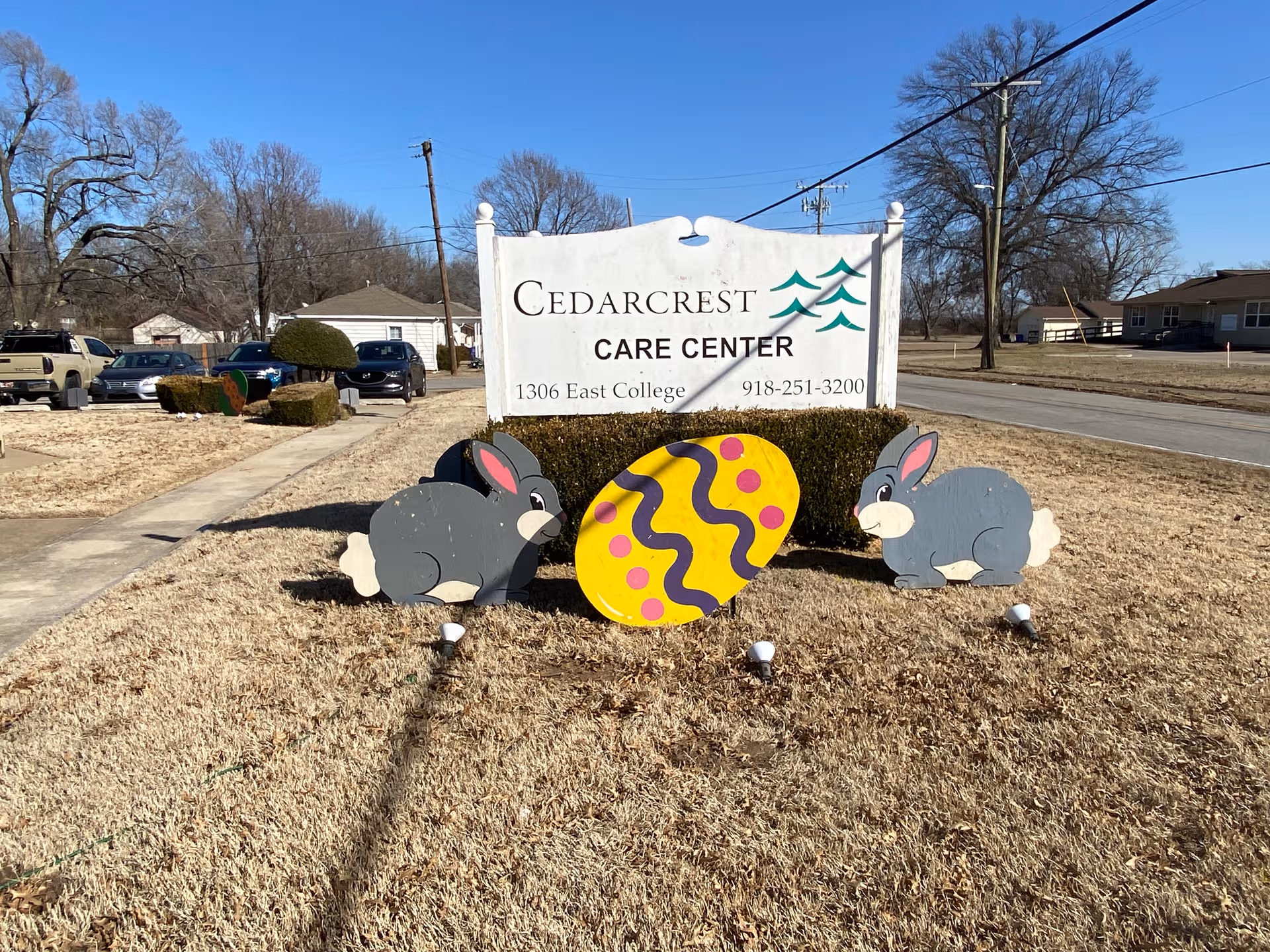 Sign reads Cedarcrest Care Center with Easter bunny and egg decorations in front yard.