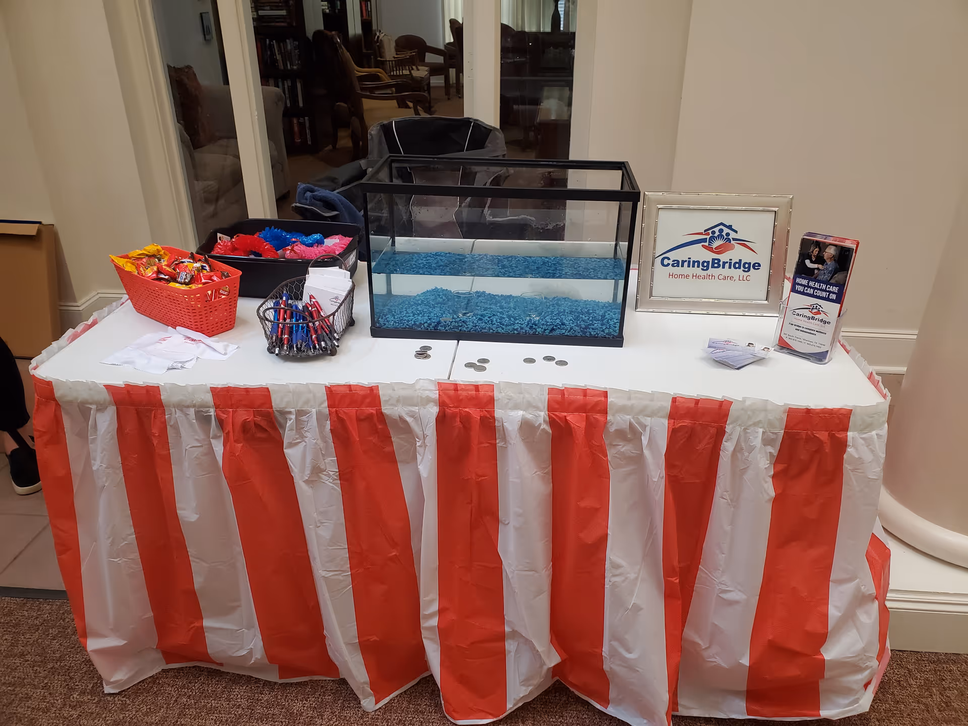 Indoor table display with CaringBridge sign, brochures, and a blue beaded tank.