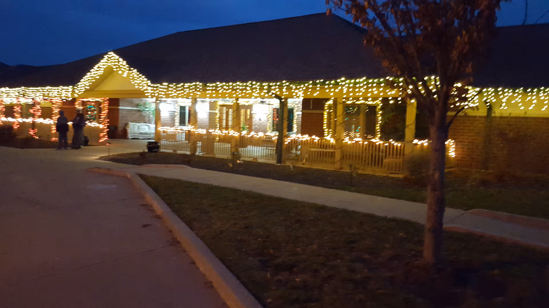Exterior of Grand Prairie of Macomb with warm holiday lights along the front.