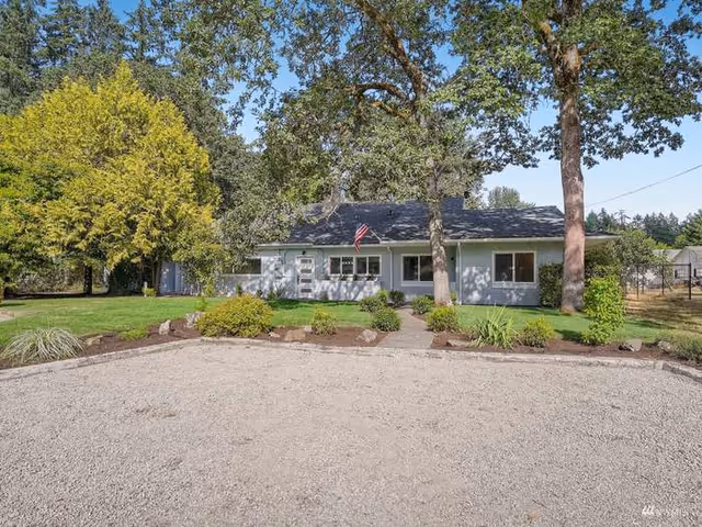 Front exterior of West Bliss Adult Family Home LLC, a ranch-style building with a gravel driveway.
