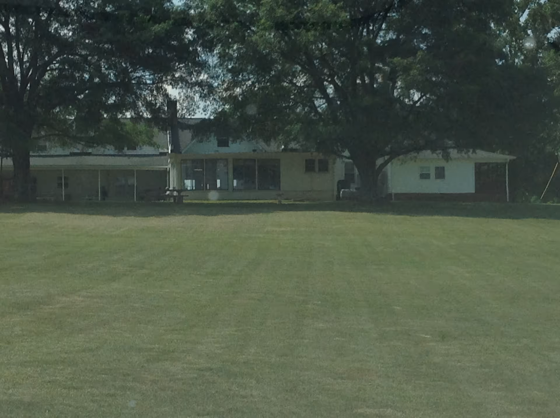 The Oakridge Community Care Home exterior with a lawn and trees.