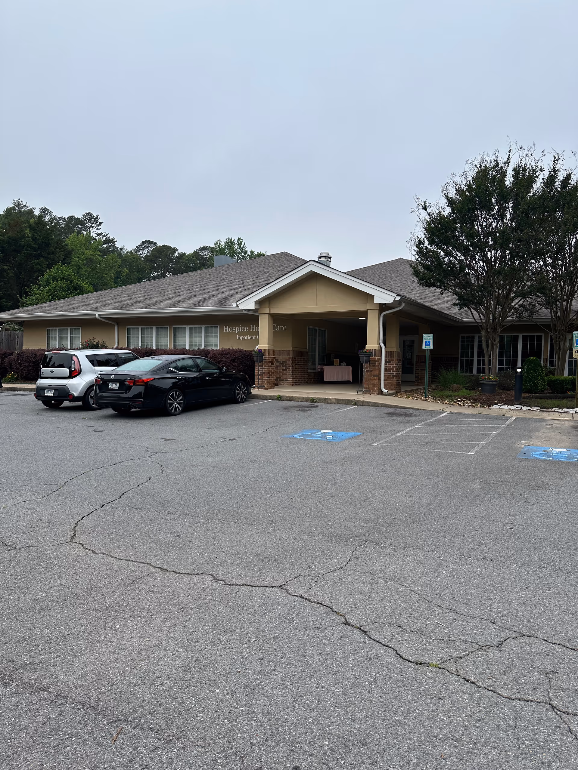 Exterior view of Hospice & Home Care facility with a covered entrance and parking.
