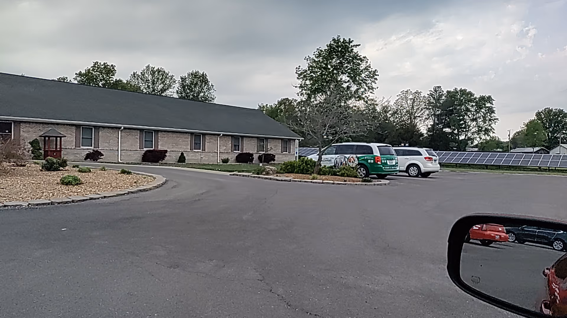 Single-story brick senior living facility with a curved driveway and parking lot.