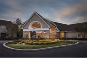 Front exterior of Meadowood Senior Living with a circular driveway and landscaped entrance.