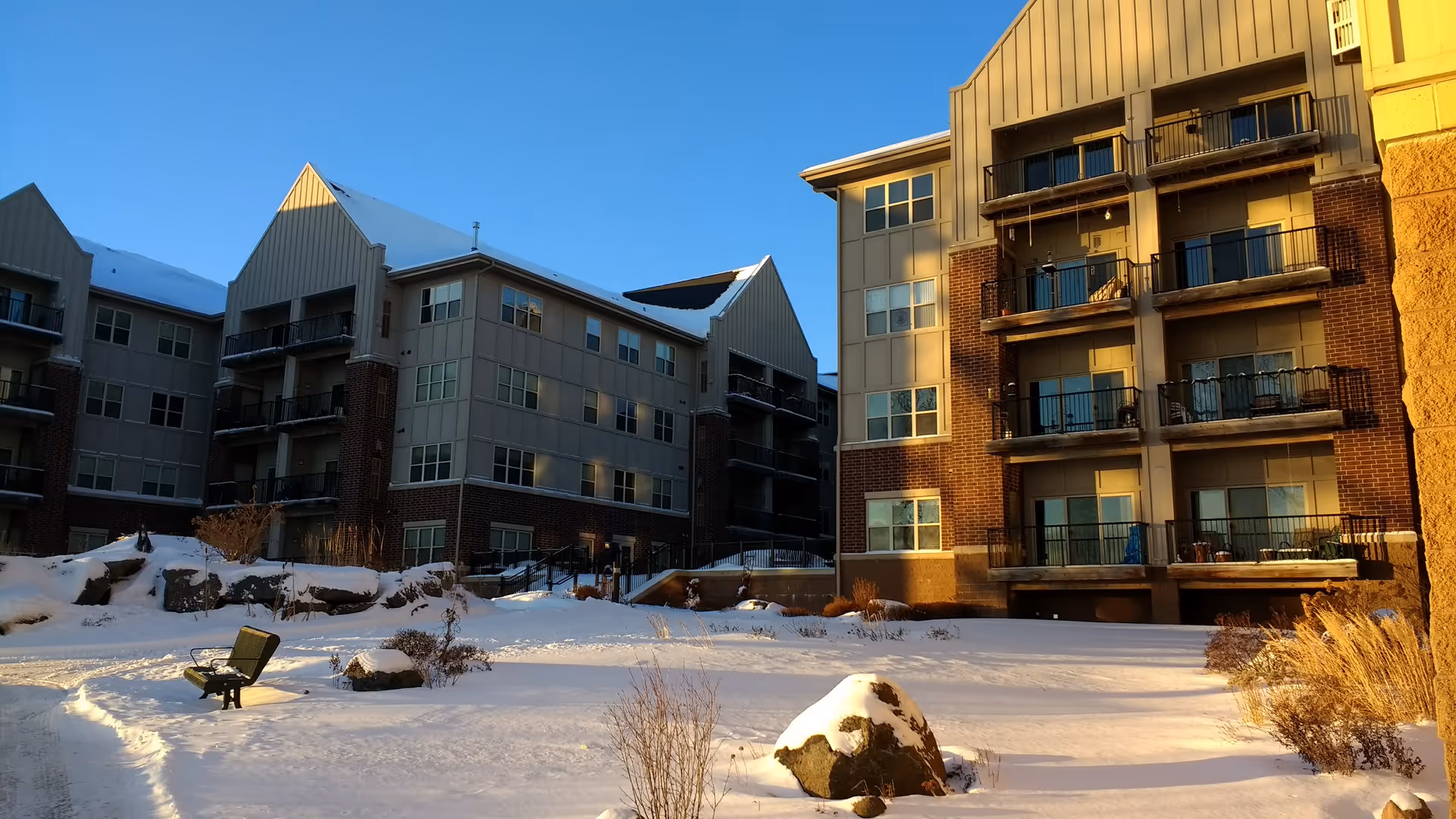 Snowy exterior of multi-story senior living buildings with balconies.