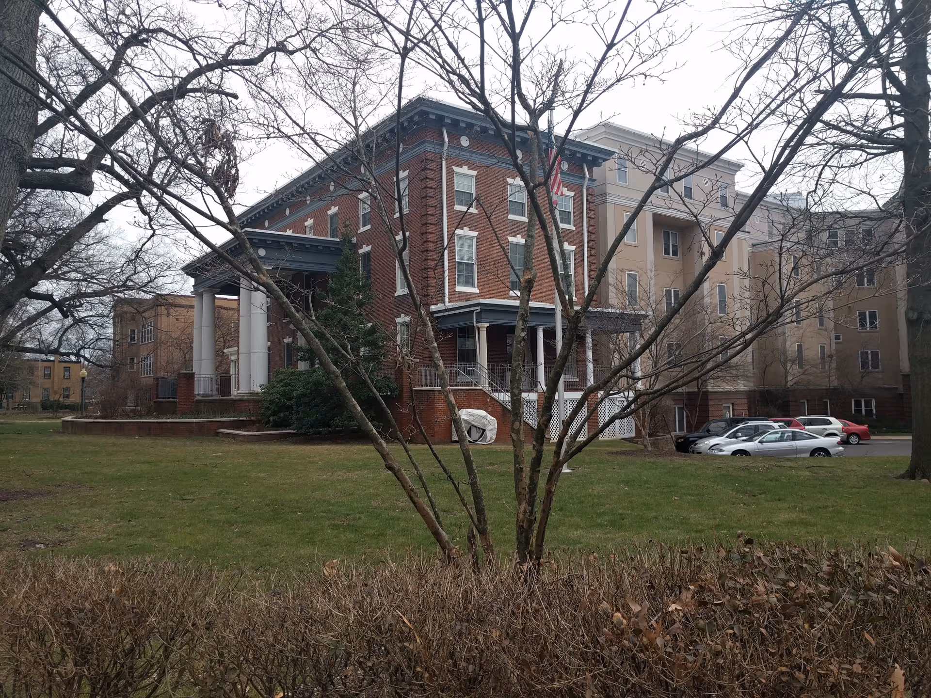 Exterior view of United Methodist Communities at Collingswood front building with lawn and cars.