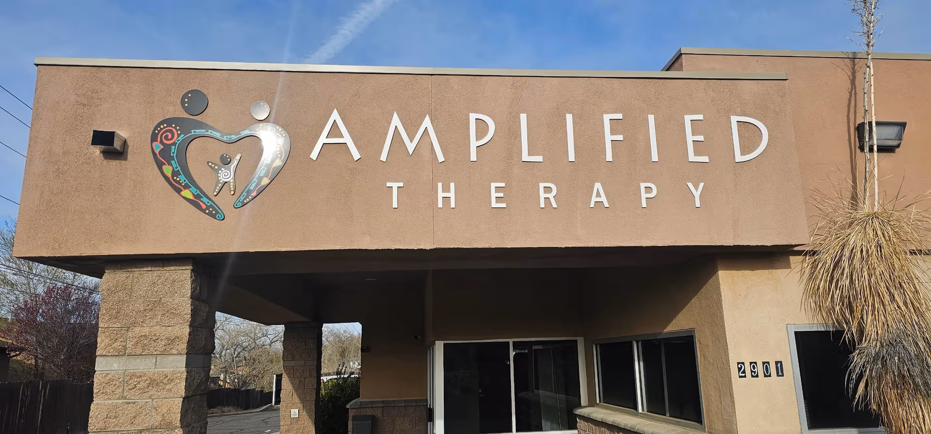Exterior view of Amplified Therapy building with entrance and large sign.
