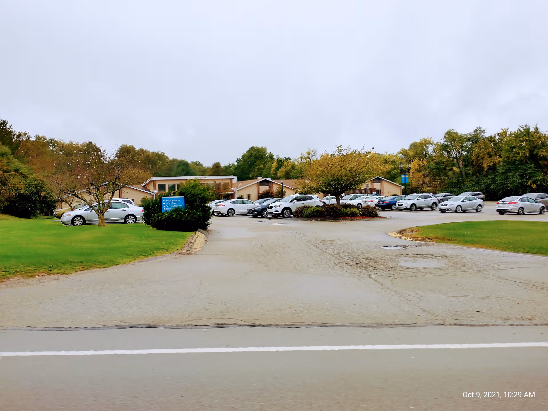 Exterior view of Transitions Healthcare North Huntingdon with parking lot and multiple parked cars.