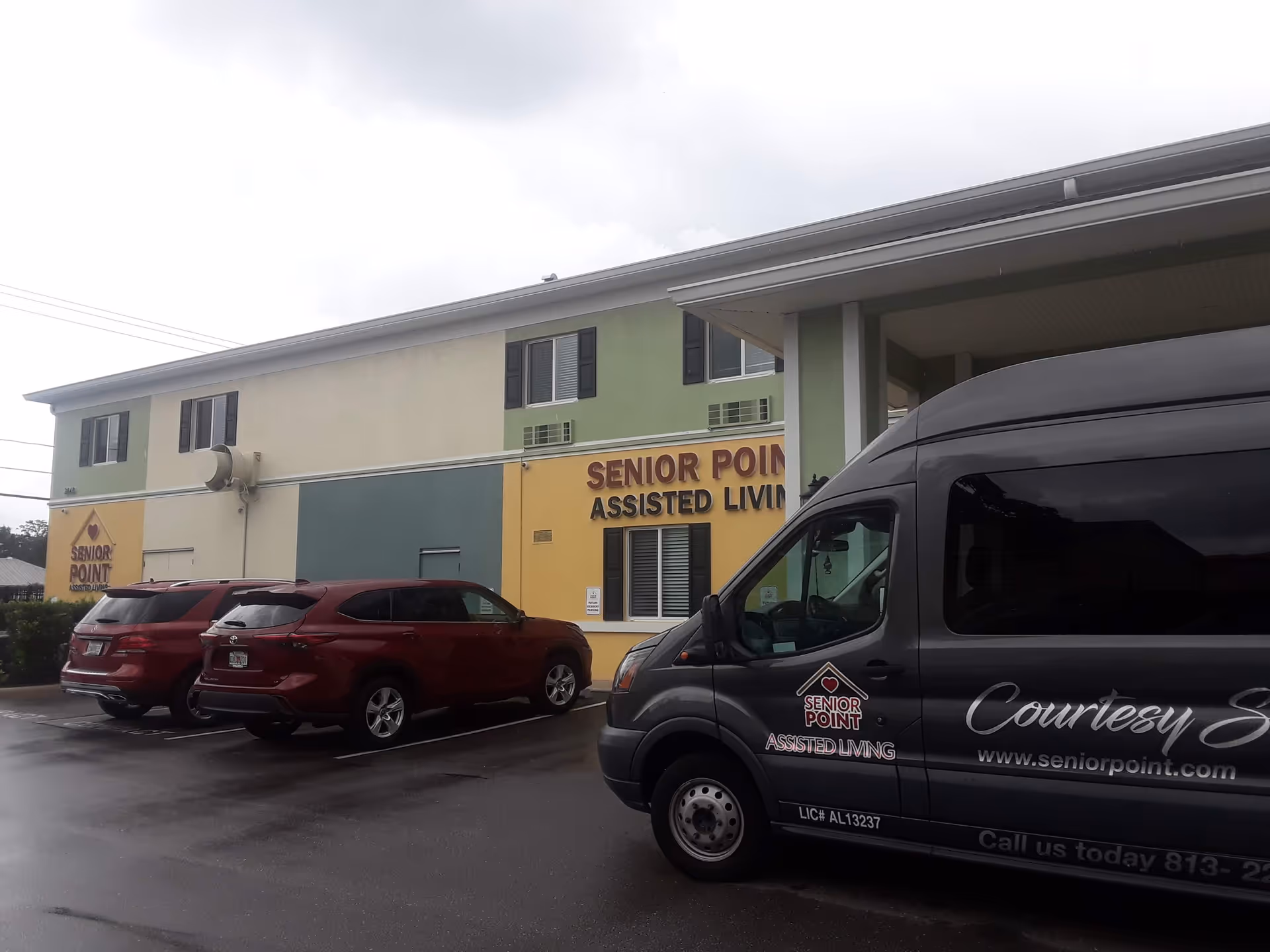 Exterior view of Senior Point Assisted Living building with parked vehicles in front.