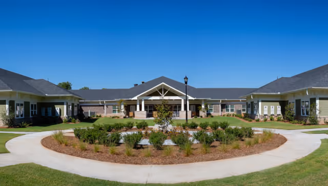 Single-story senior living facility with circular driveway and landscaped front courtyard.