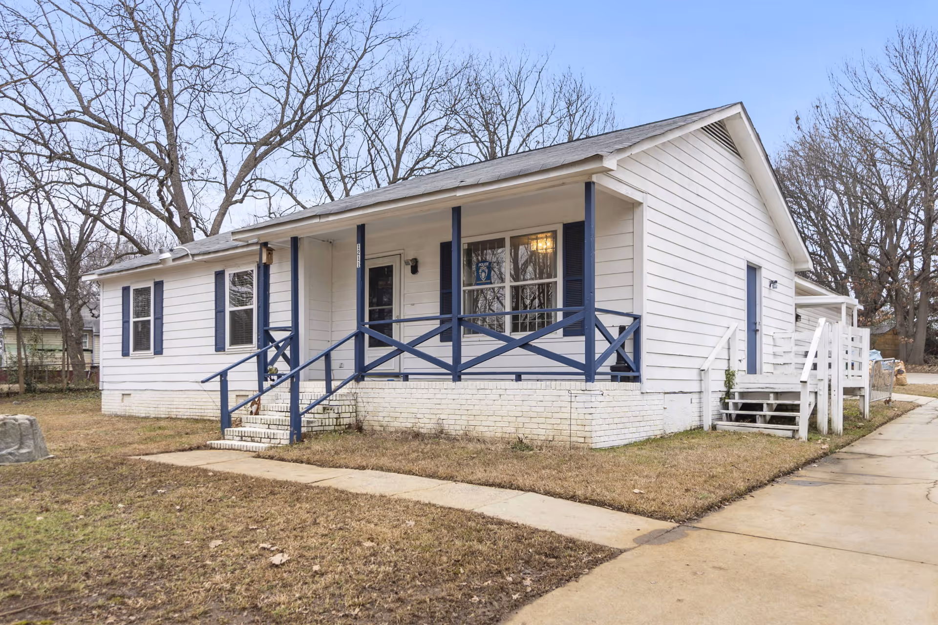White one-story senior care house with blue railing and a front porch.
