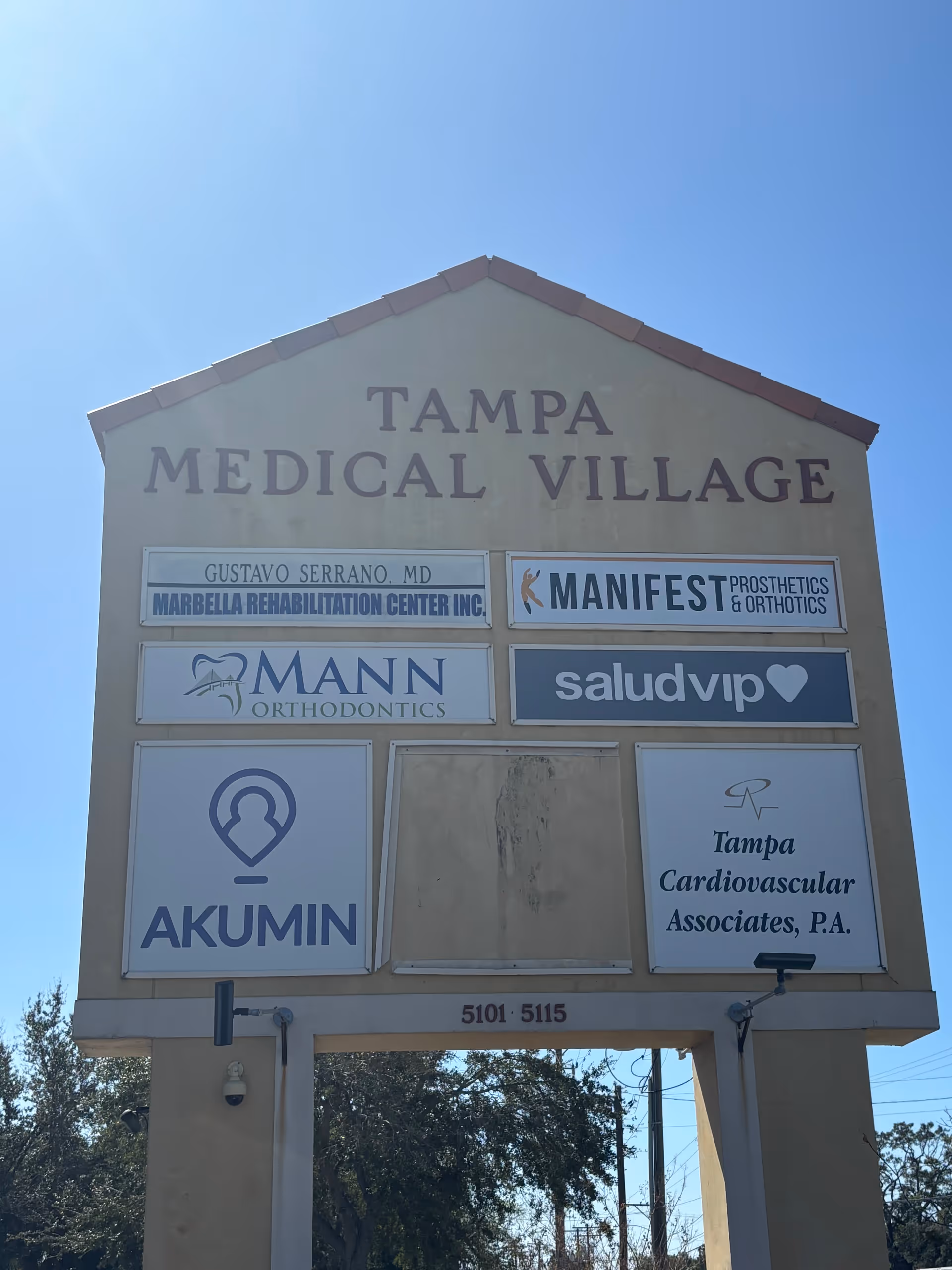 Exterior sign for Tampa Medical Village displaying multiple medical tenants and logos.