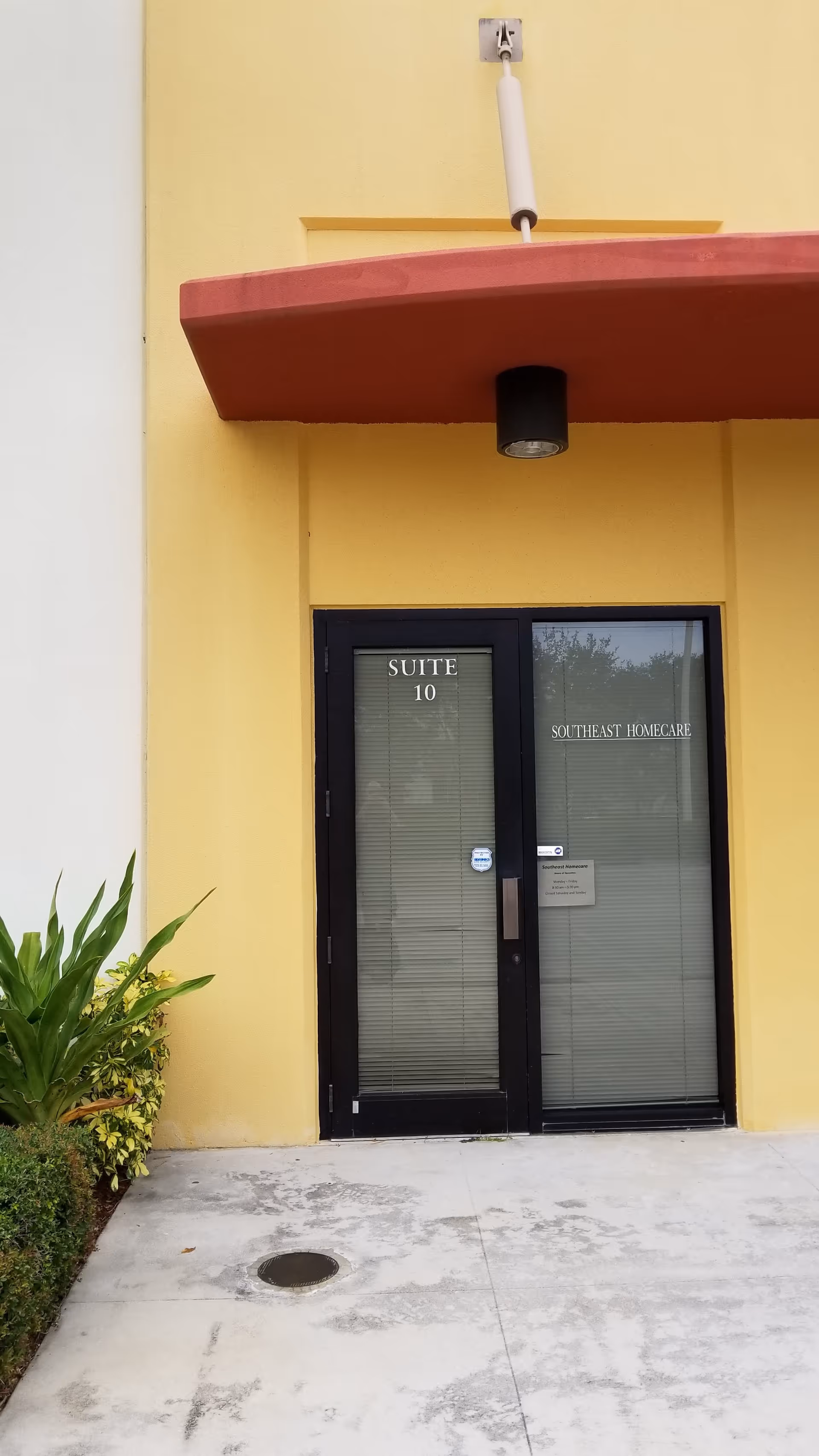 Yellow building exterior with black double doors labeled Suite 10 and Southeast Homecare