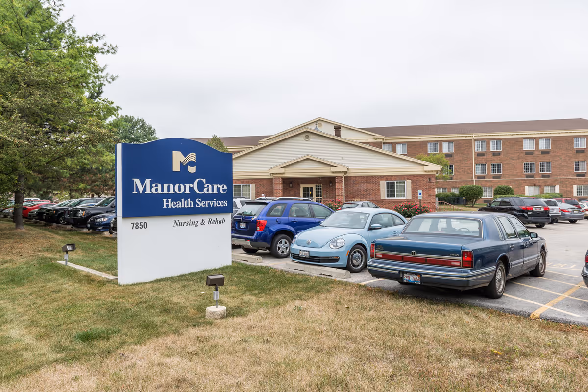 Front exterior view of ManorCare Health Services with a parking lot and entrance.