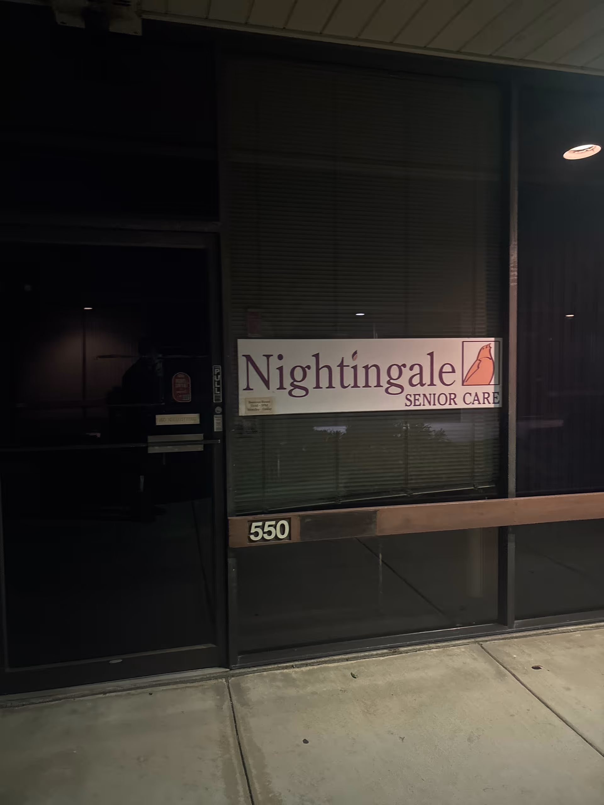Nightingale Senior Care sign on glass storefront with dark entrance and street sidewalk.