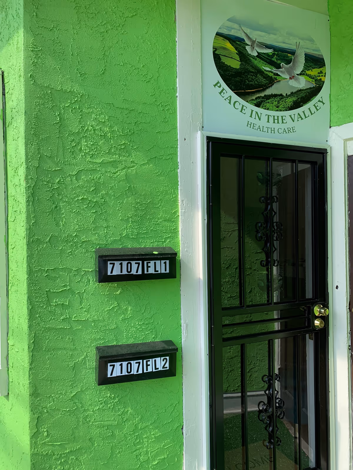 Bright green building exterior with a gated entrance and Peace in the Valley Health Care sign.