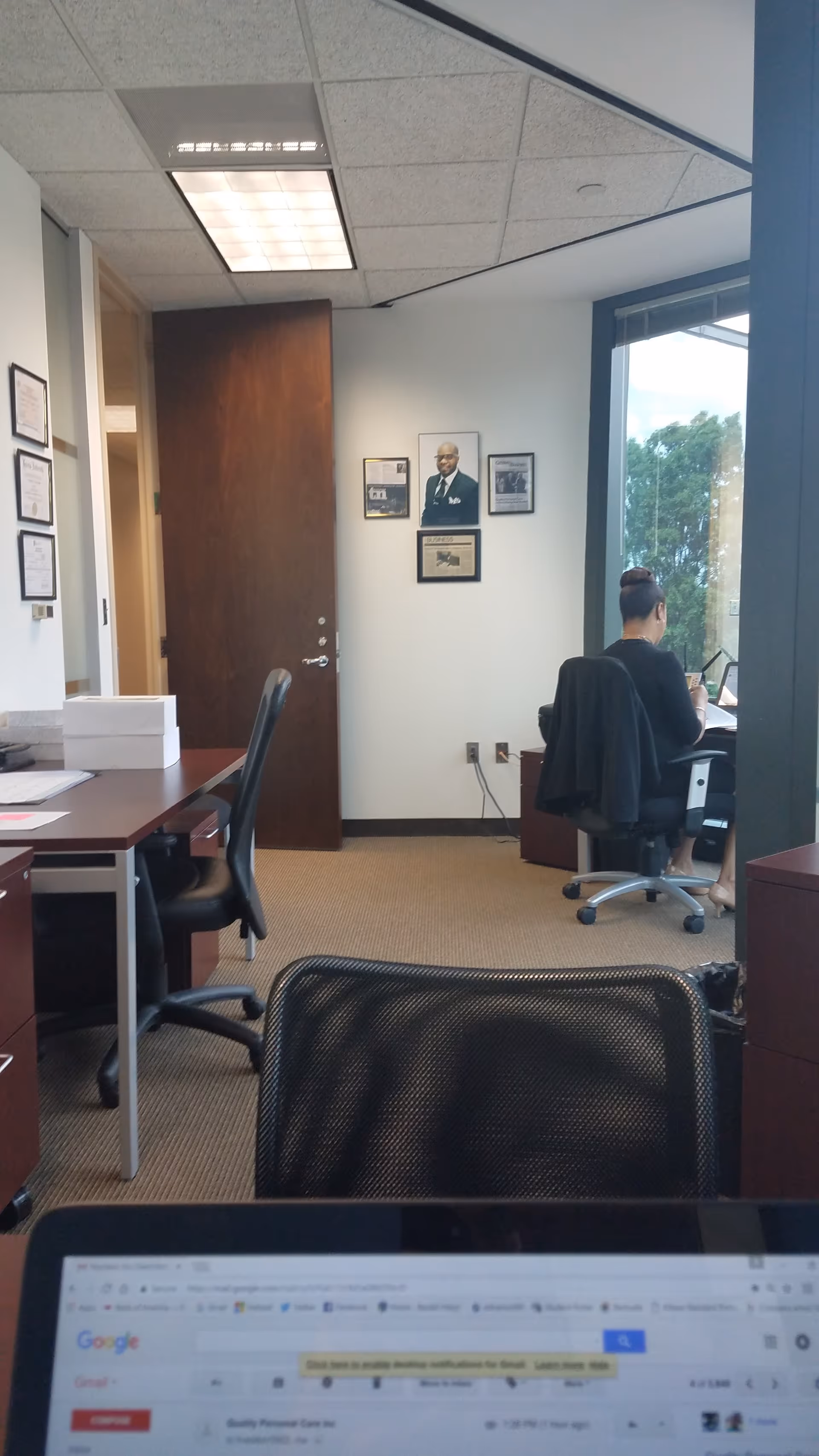 Office area inside a senior care facility with desks, chairs, and framed pictures.