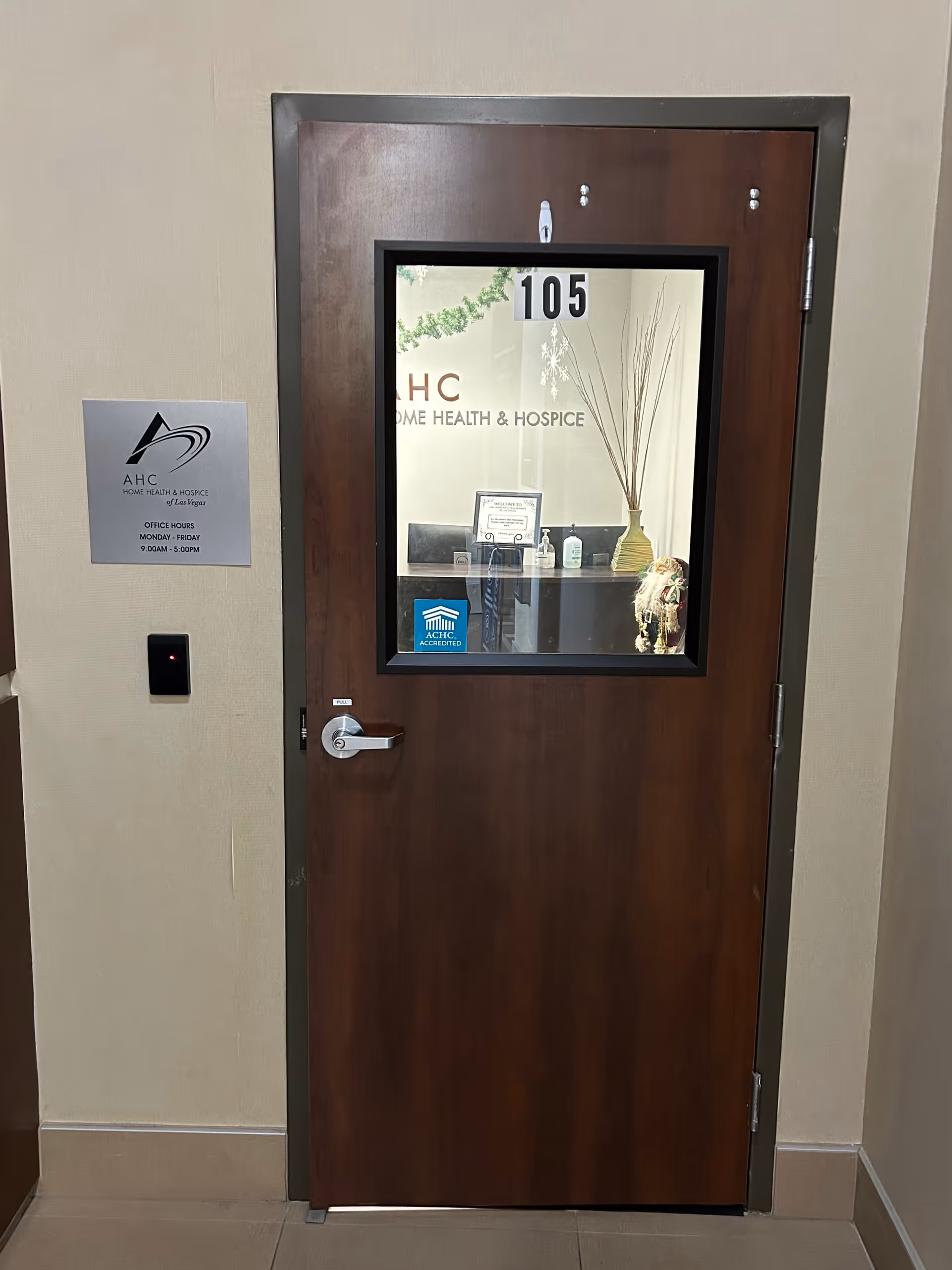 Wooden door labeled 105 in a beige hallway, with AHC Home Health & Hospice signage.