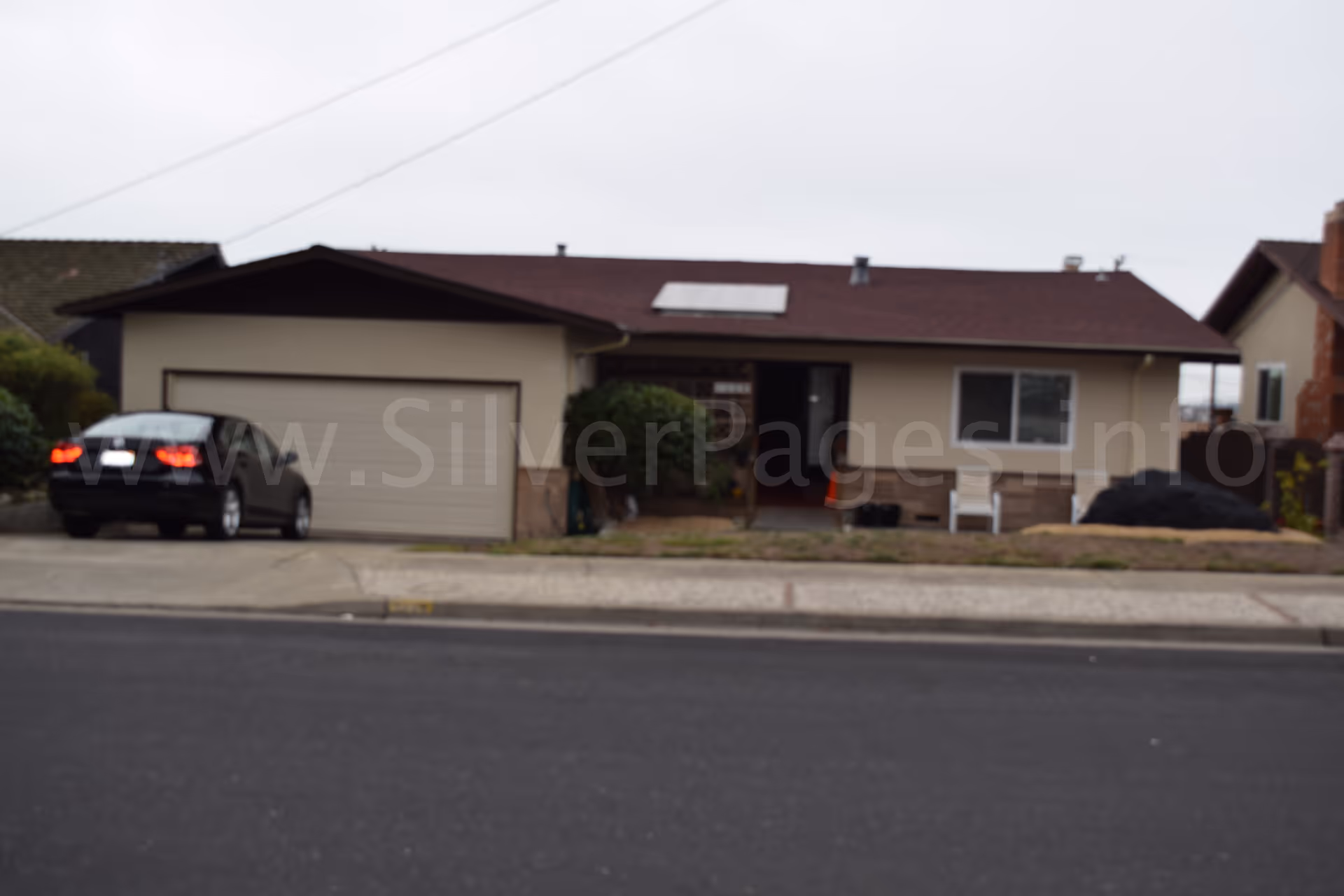 Front exterior of a single-story home with a two-car garage and parked car.